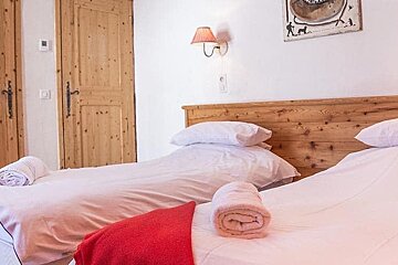 A bedroom with two beds and a painting on the wall