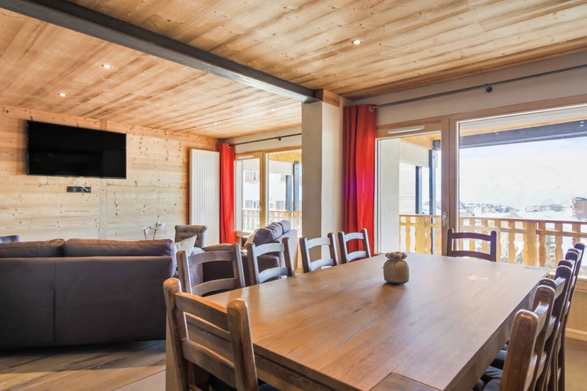 A living room with a table and chairs and a flat screen tv