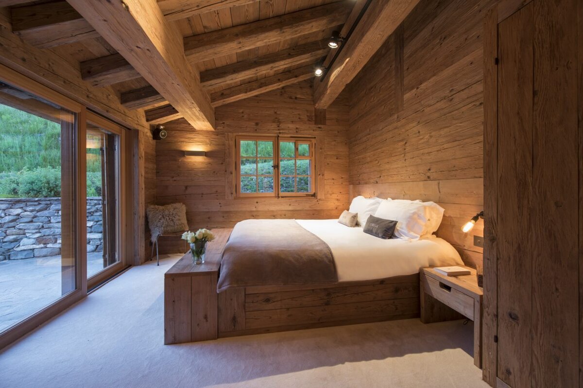 A bedroom with wooden walls and a bed