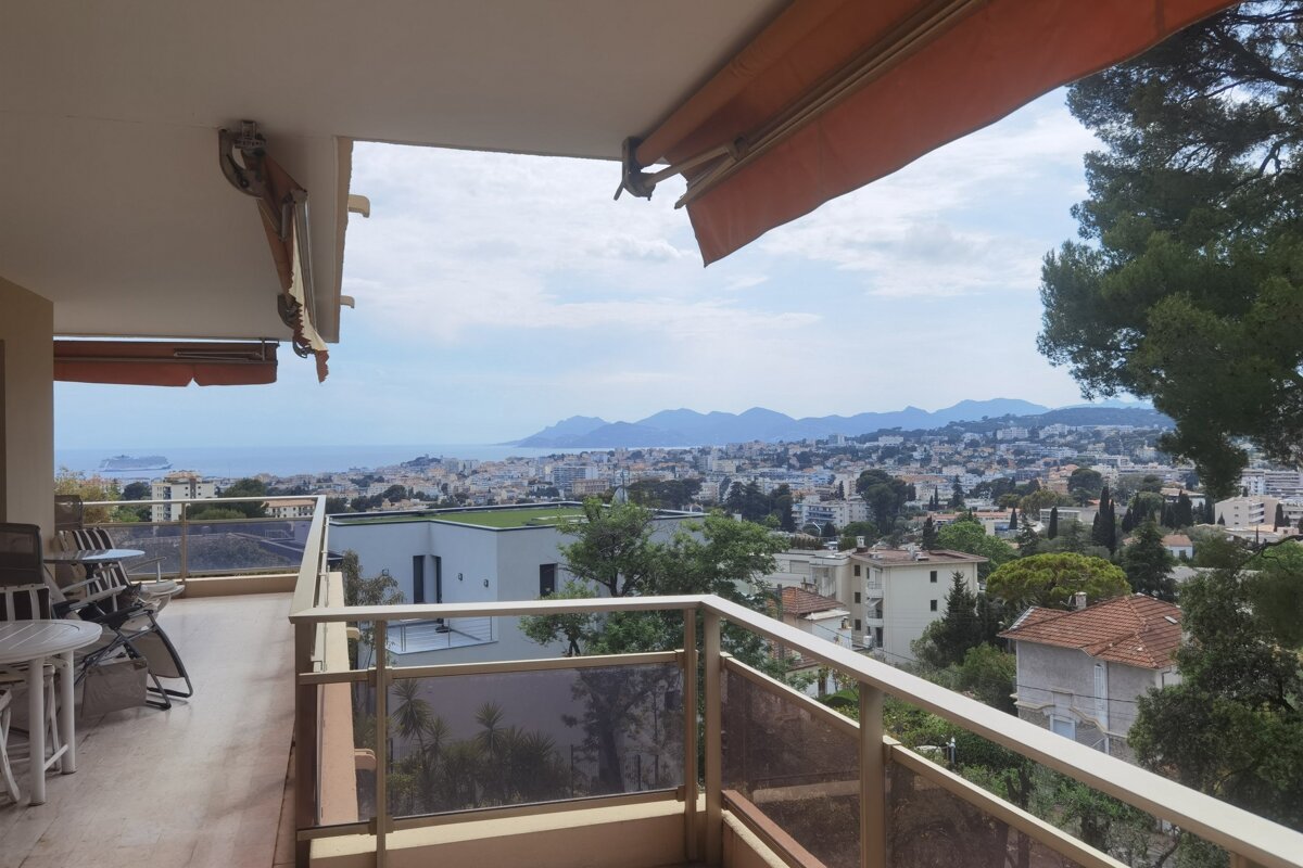 A balcony with a view of a city and mountains