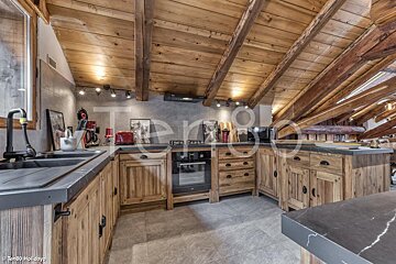 A kitchen with a wooden ceiling and a sink