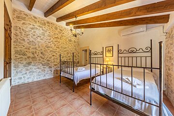 A bedroom with two beds and a ceiling fan