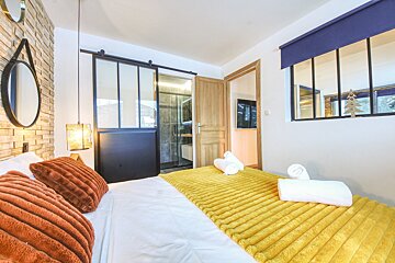 A bedroom with a sliding glass door leading to a bathroom
