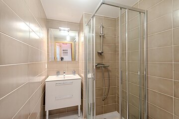 A bathroom with a walk in shower and a sink