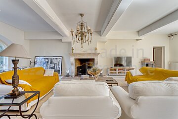 A living room with a yellow couch and a white couch