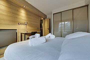 A bedroom with sliding glass doors and a desk