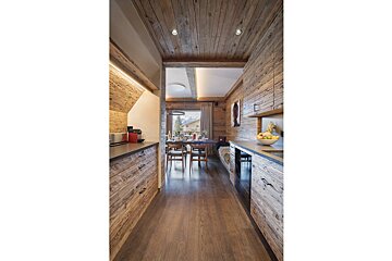 A kitchen with wooden cabinets and a bowl of fruit on the counter