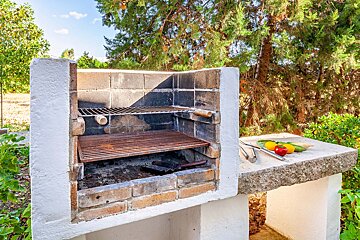 A brick grill with a few vegetables on it