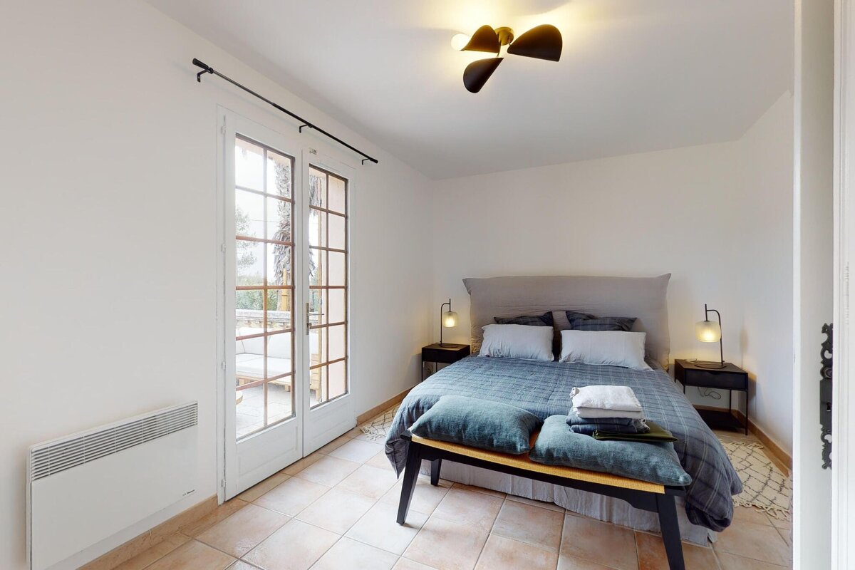 A bedroom with a large bed and a bench