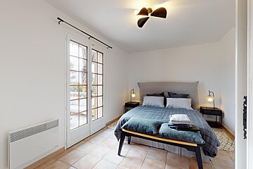 A bedroom with a large bed and a bench