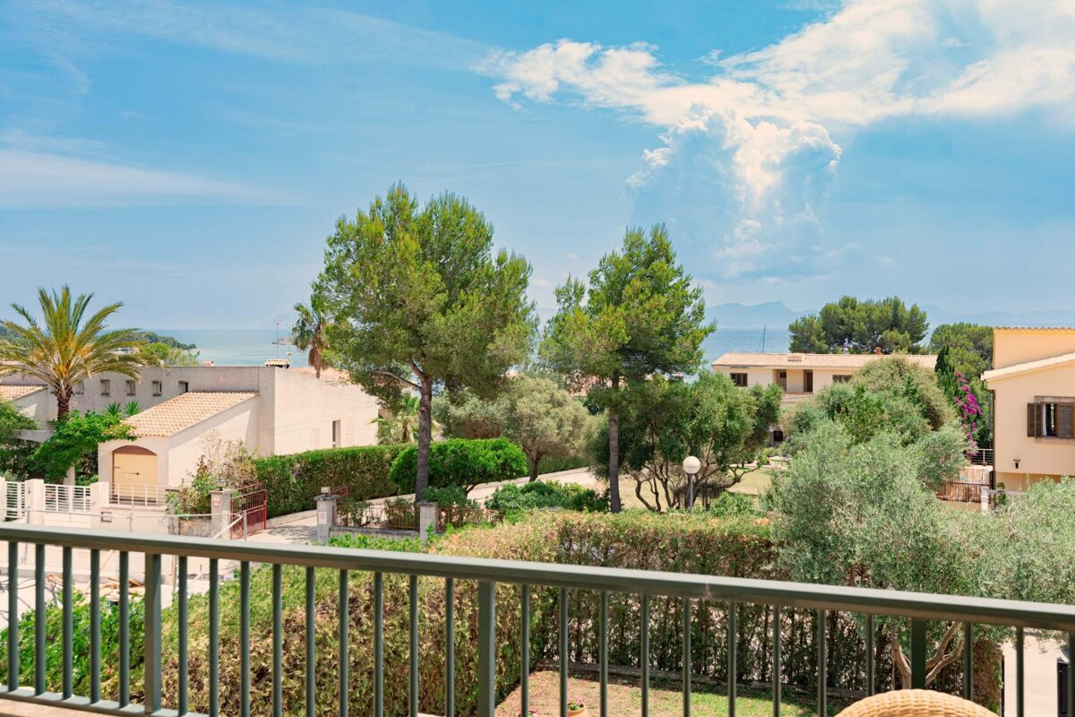 A balcony with a view of houses and trees