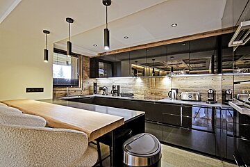 A kitchen with black cabinets and appliances including a toaster