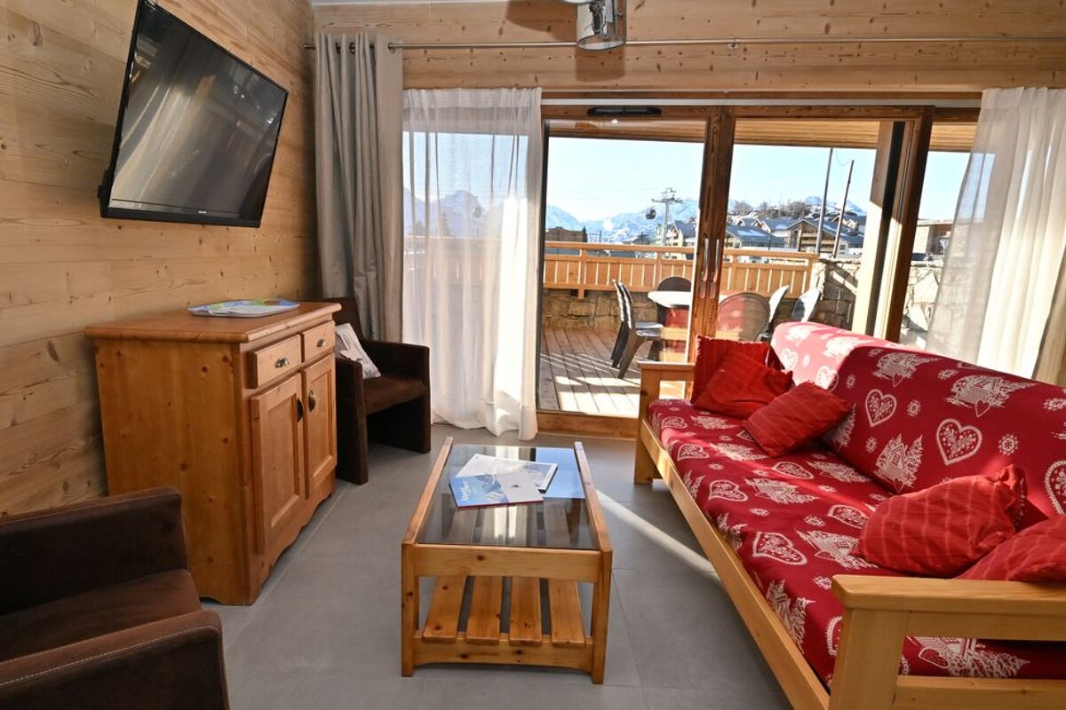 A living room with a red couch and a flat screen tv