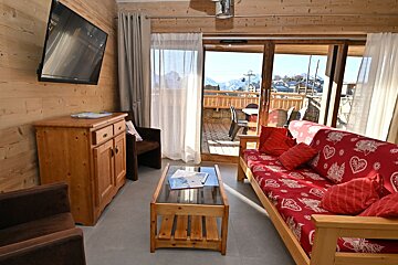 A living room with a red couch and a flat screen tv