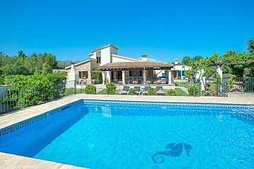 A large house with a swimming pool in front of it