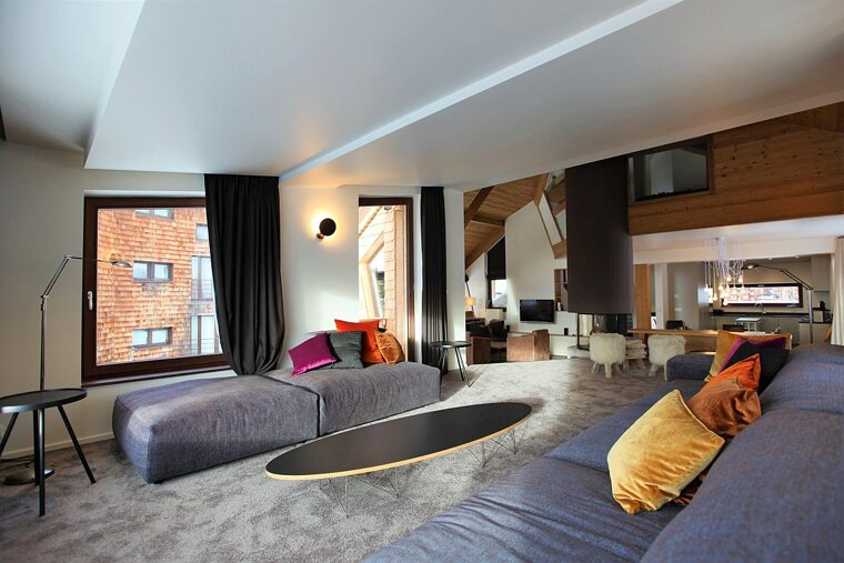 A living room with a blue couch and a black coffee table
