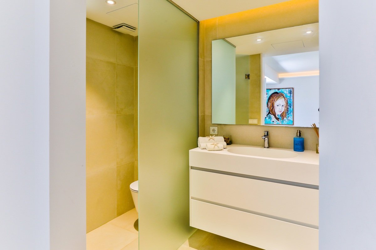 A bathroom with a painting on the wall above the sink