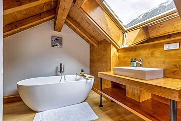 A bathroom with a white bathtub and a sink