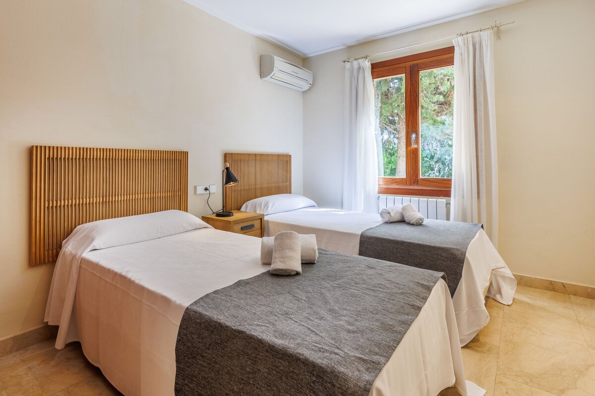 A bedroom with two twin beds and a window