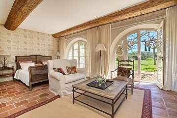 A bedroom with a couch a chair and a coffee table