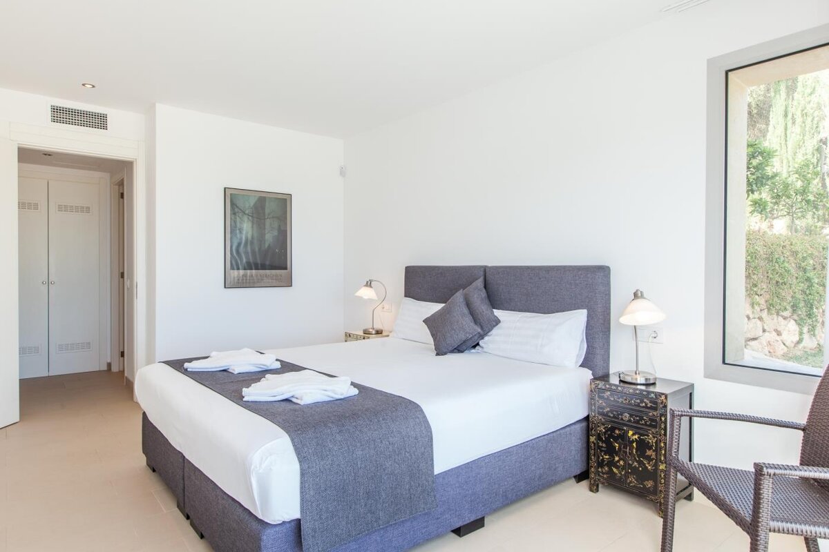 A bedroom with a large bed and a picture on the wall