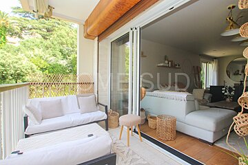 A balcony with a couch and a chair with the word home sud on it