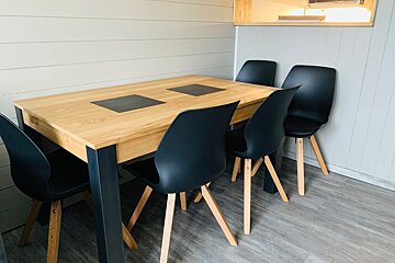 A wooden table with black chairs in a room