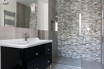 A bathroom with a sink and a walk in shower