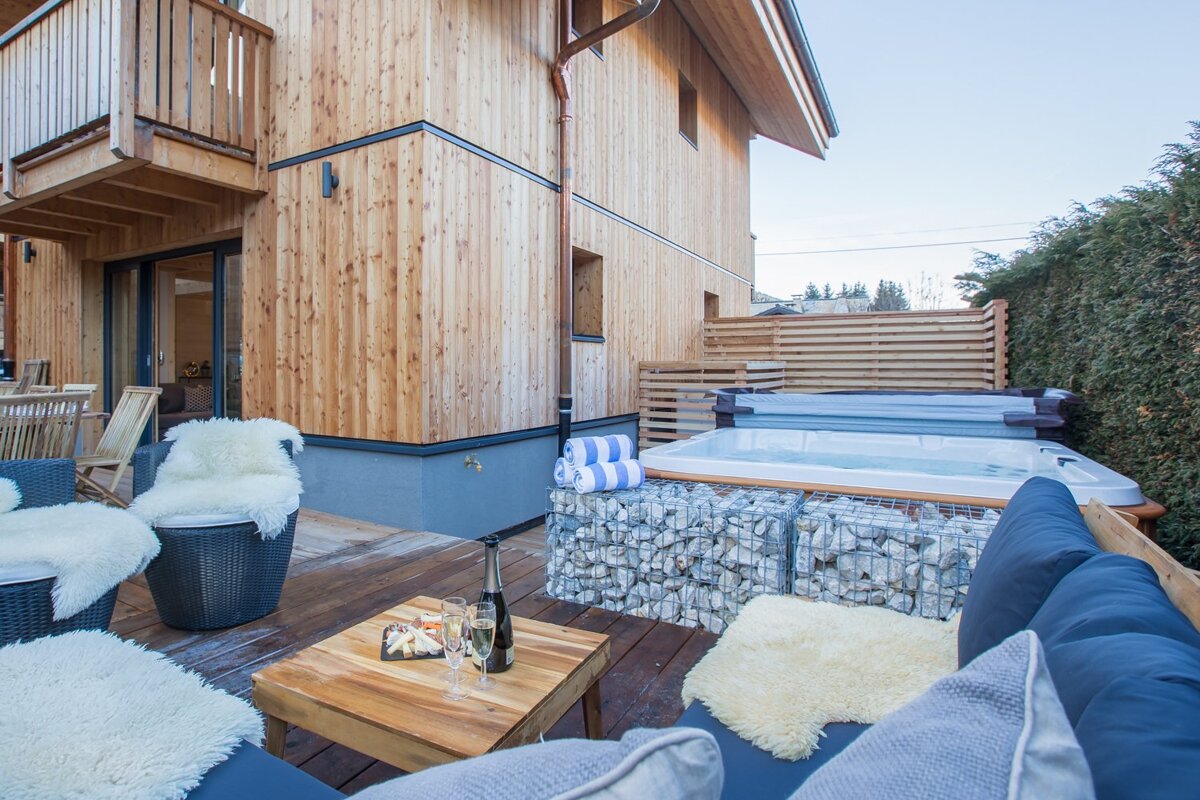 A wooden house with a hot tub in front of it