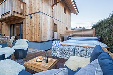 A wooden house with a hot tub in front of it