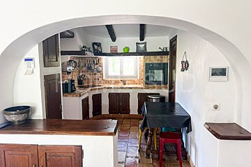 A kitchen with a black table cloth and red stools