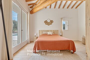 A bedroom with a bed and a sign that says made in janssens provence by immobilier