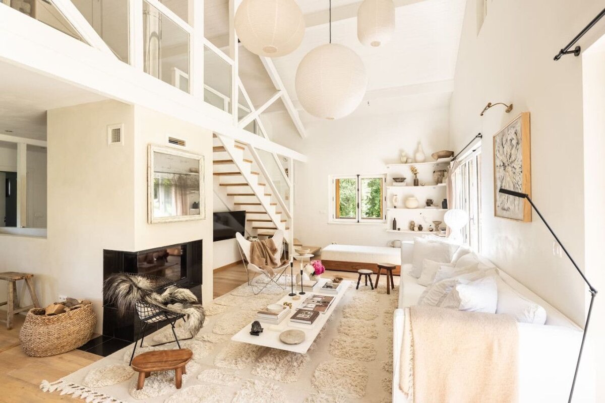 A living room with white furniture and a fireplace