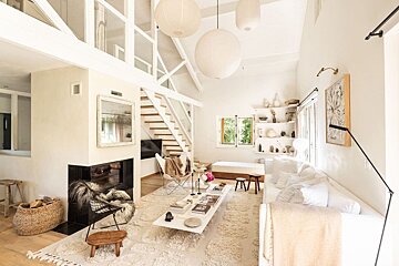 A living room with white furniture and a fireplace