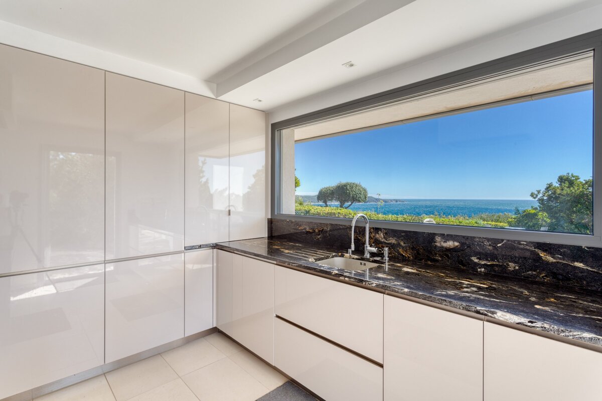 A kitchen with a large window overlooking the ocean