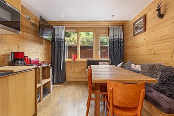 A kitchen with wood paneling and a table and chairs