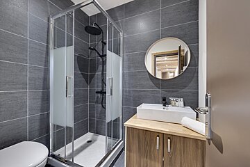 A bathroom with a toilet a sink and a shower