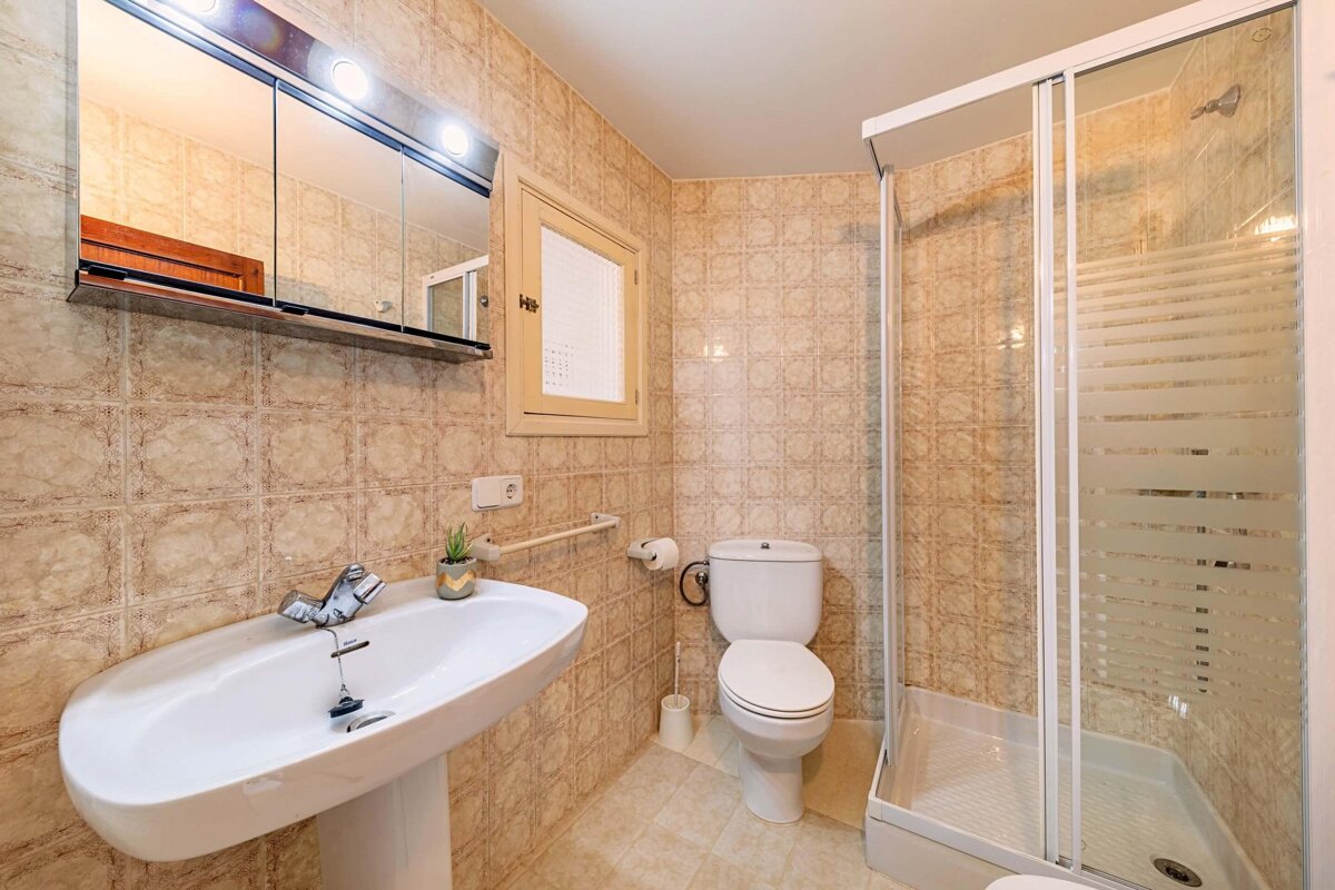 A bathroom with a toilet a sink and a shower