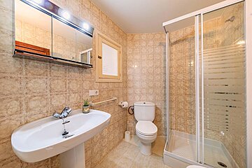 A bathroom with a toilet a sink and a shower