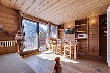 A wooden room with a dining table and chairs
