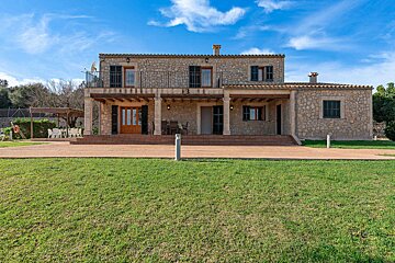 A large stone house with a large lawn in front of it