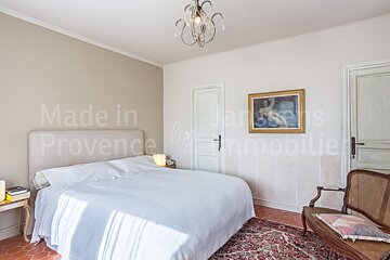 A bedroom with a bed and a painting that says made in provence