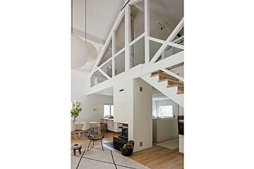 A white room with a fireplace and stairs