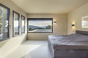 A bedroom with a bed and a window that says made in provence