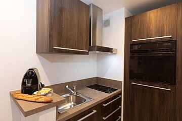 A kitchen with a krups coffee maker and a loaf of bread