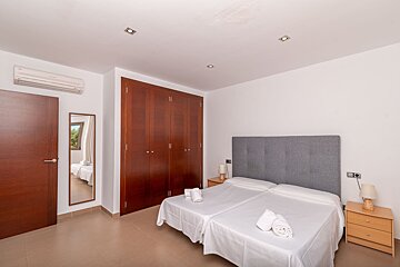 A bedroom with two beds and a mirror