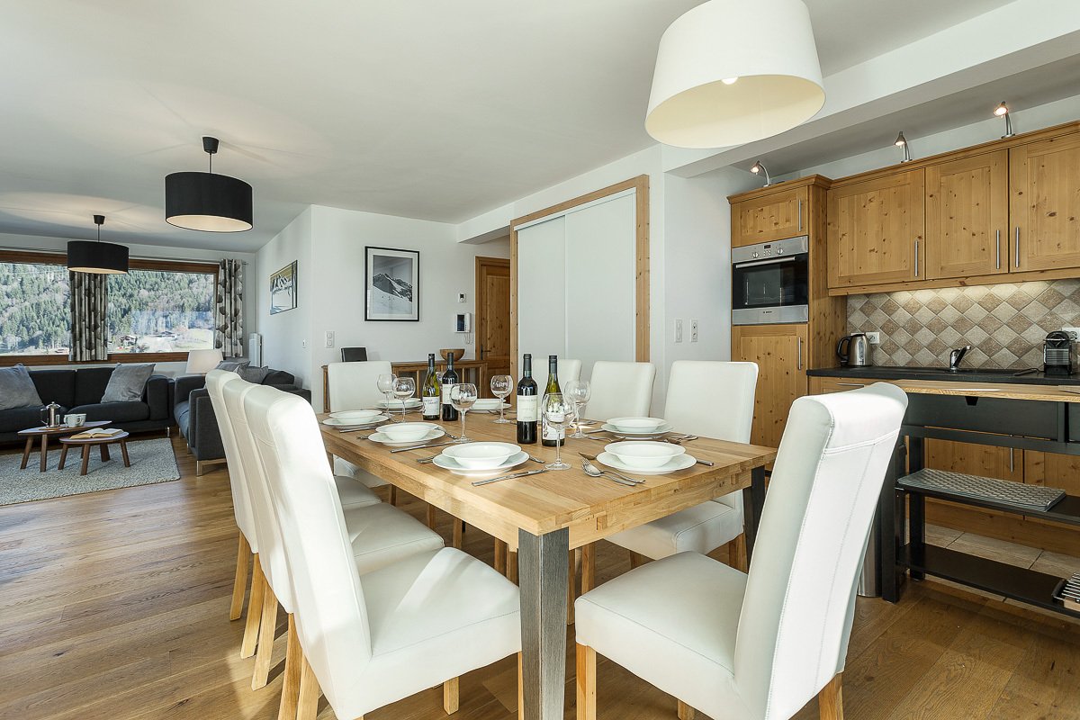 A dining room table with a bottle of wine on it