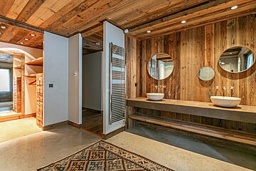 A bedroom with wood paneled walls and a bed