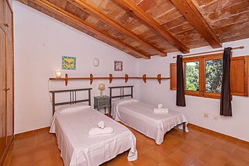 A bedroom with two twin beds and a window