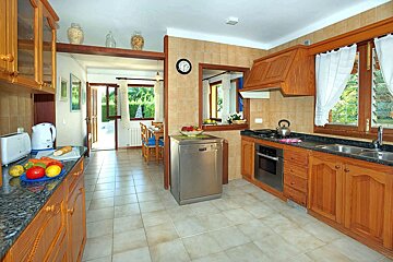 A kitchen with a dishwasher and a clock on the wall